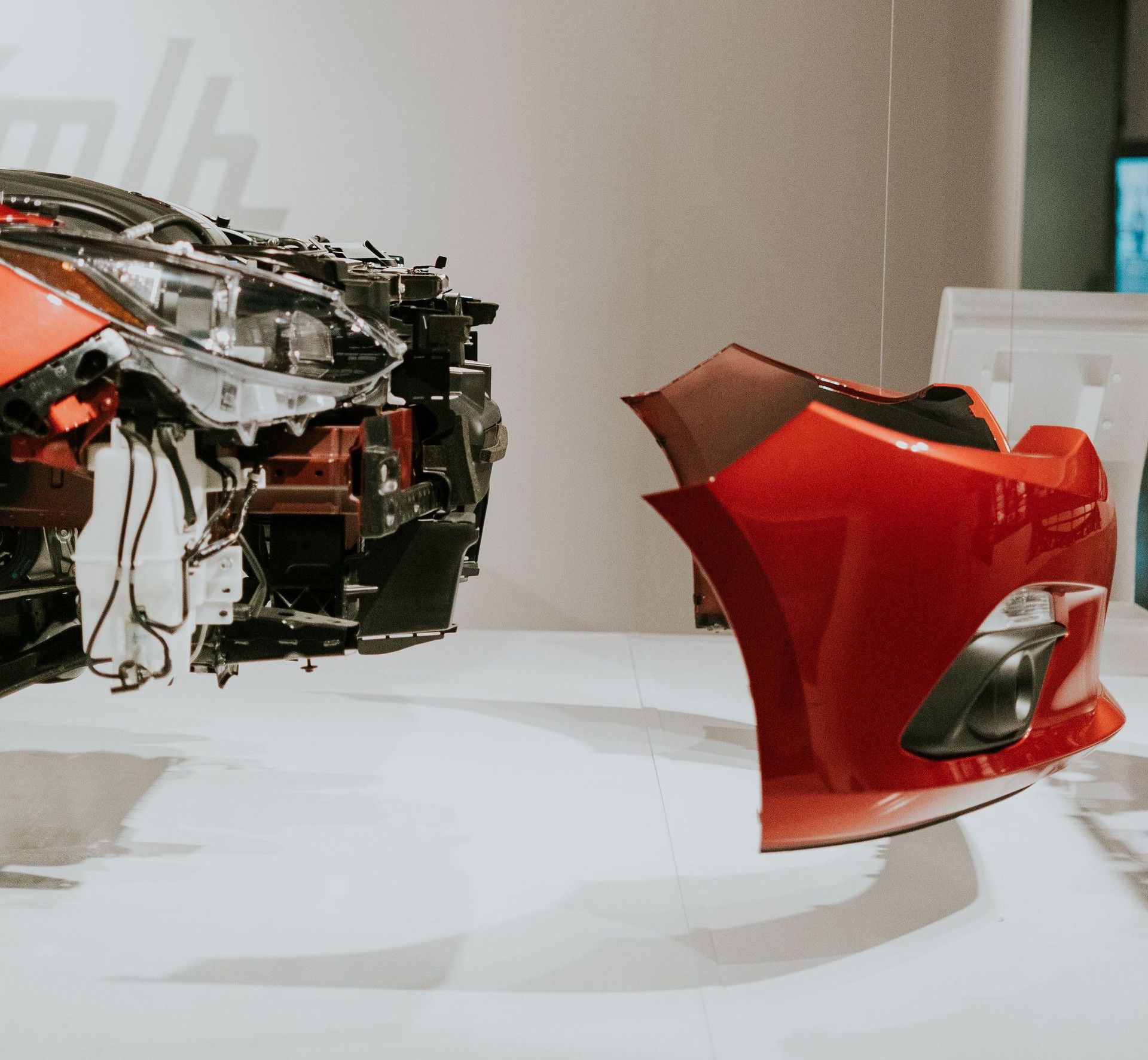 A detailed view of disassembled car parts hanging in a modern exhibit setup.